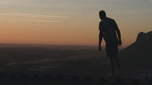 Reis Een Man Staat Een Berg Kijkt Naar Zonsondergang — Stockvideo