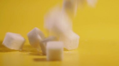 Sugar. Sugar is falling slowly on a yellow background.