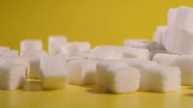 Sugar. Sugar in cubes lies on a yellow background.