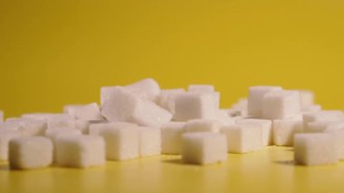 Sugar. Sugar in cubes lies on a yellow background.