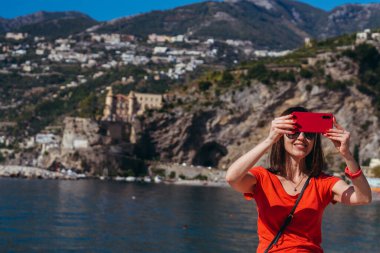 Cep telefonu. Bir kadın cep telefonuyla kendini vuruyor. Pozitano. İtalya.