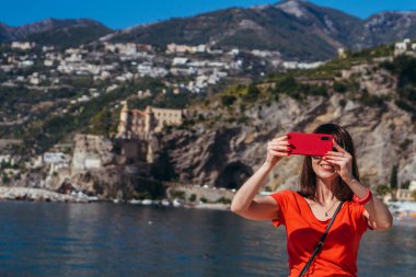 Cep telefonu. Bir kadın cep telefonuyla kendini vuruyor. Pozitano. İtalya.