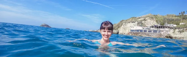 Sea. A girl swims in the sea. Italy.