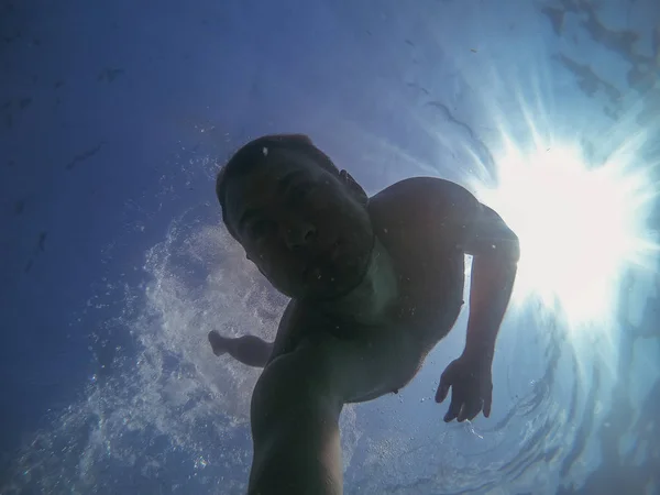 Sea. The guy swims underwater and takes pictures of himself on camera. Italy. Mediterranean Sea.