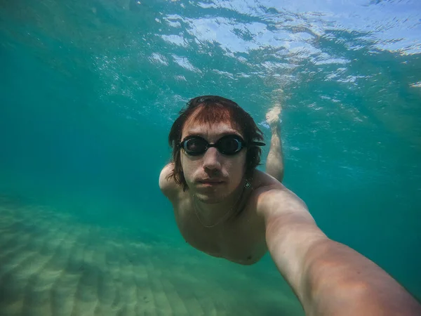 男は水中で泳いで カメラで自分の写真を撮る イタリアだ 地中海 — ストック写真