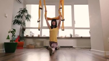 Şarj oluyor. Kadın sicimin üzerinde oturmaya çalışıyor..