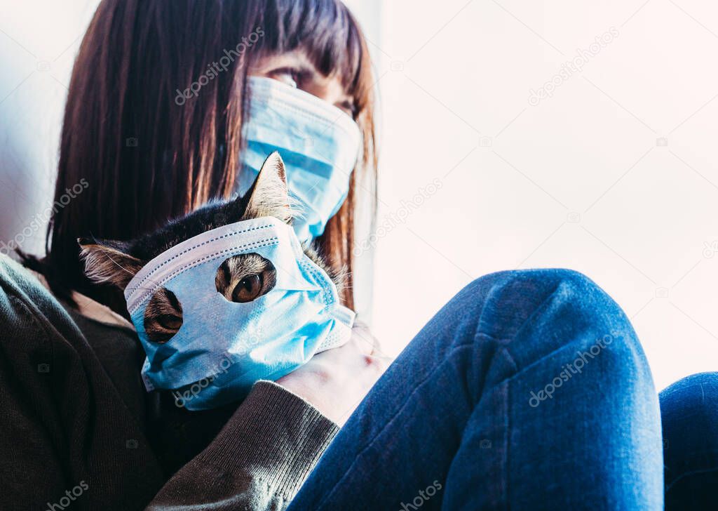 Virus. A woman is sitting with a cat in a protective gauze mask from the virus.