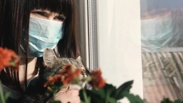 ウイルスだ ウイルスからの保護ガーゼのマスクに猫と一緒に座っている女性 — ストック動画