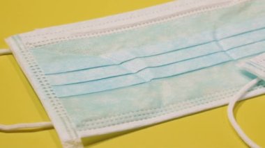 Virüs. Sarı arka planda tıbbi koruyucu maskeler var..