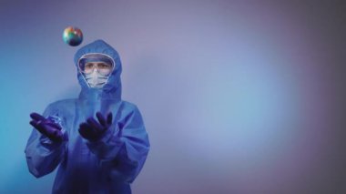 Virüs. Virüse karşı koruyucu giysi giyen bir doktor Dünya gezegeni şeklinde bir top fırlatıyor..