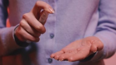 El dezenfeksiyonu. Kadın ellerini virüse karşı antiseptik spreyle dezenfekte ediyor..