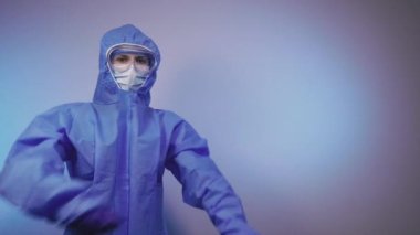 Virüs. Bir doktor virüse karşı koruyucu bir tıbbi giysinin içinde duruyor..