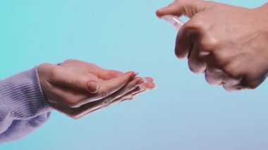 El dezenfeksiyonu. Kadın ellerini virüse karşı antiseptik spreyle dezenfekte ediyor..