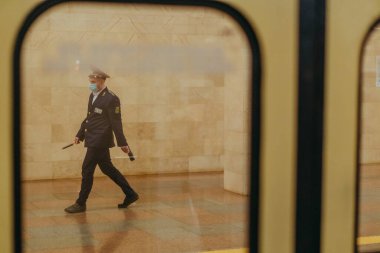 KYIV, UKRAINE - 17 Mart. 2020 yılı. Kiev metrosunun karantinaya alınması. Virüs için tıbbi maskeli bir metro çalışanı..