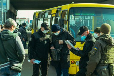 KYIV, UKRAINE - 19 Mart. 2020 yılı. COVID-19 virüsü yüzünden Kiev şehrinde karantina var. Polis, minibüs şoförünü on kişiden fazla yolcu taşıması için sigortaladı..