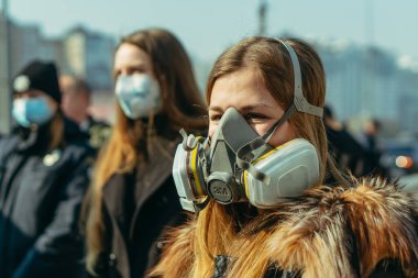 KYIV, UKRAINE - 19 Mart. 2020 yılı. COVID-19 virüsü yüzünden Kiev şehrinde karantina var. İnsanlar virüse karşı koruyucu maskelerle toplu taşıma duraklarında duruyorlar..
