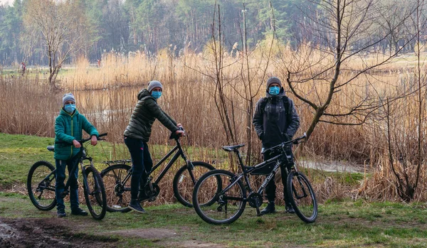 Kyiv Ukraine 3月19日 2020年 Covid 19ウイルスによるキエフ市内の隔離 医療用マスクの若い家族が公園で自転車に乗る — ストック写真