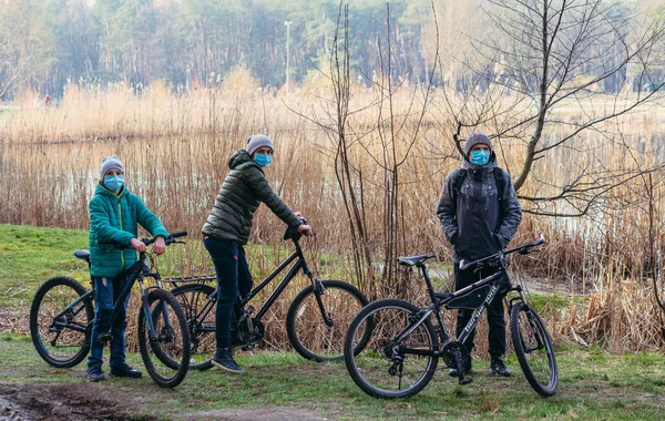 Kyiv Ukraine 3月19日 2020年 Covid 19ウイルスによるキエフ市内の隔離 医療用マスクの若い家族が公園で自転車に乗る — ストック写真