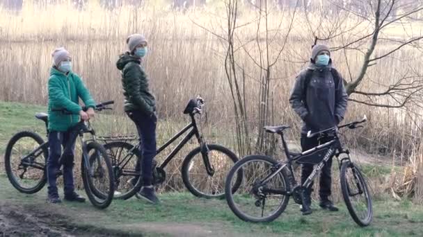 Kyiv Ukraine 3月19日 2020年 Covid 19ウイルスによるキエフ市内の隔離 医療用マスクの若い家族が公園で自転車に乗る — ストック動画