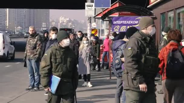 Kyiv Ukraine 3月19日 2020年 Covid 19ウイルスによるキエフ市内の隔離 人々は公共交通機関の停留所でウイルスから保護マスクに立っている — ストック動画