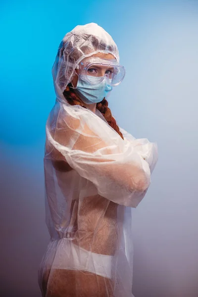 Virus. A woman in a transparent medical suit in a medical mask and glasses.