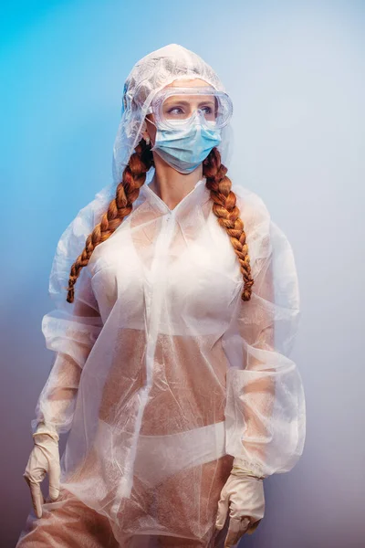 Virus. A woman in a transparent medical suit in a medical mask and glasses.