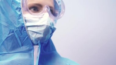 Antivirüs kostümü. Güvenlik gözlüklü, tıbbi maskeli ve antivirüs kostümlü bir kadın..