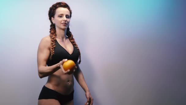 果物だ スリムな姿の女性がオレンジを投げます — ストック動画