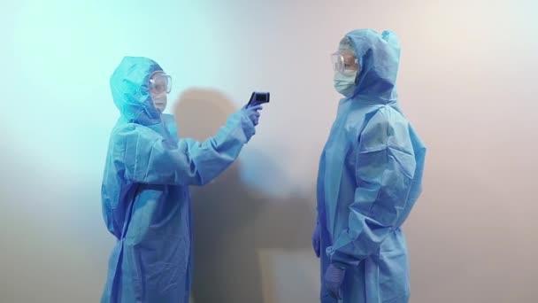 Virus Woman Medical Suit Measures Temperature Another Person — Stock Video