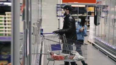 KYIV, UKRAINE - 27 Mart. 2020 yılı. COVID-19 virüsü yüzünden Kiev şehrinde karantina var. Tıp maskeli insanlar süpermarketten yiyecek satın alıyorlar..