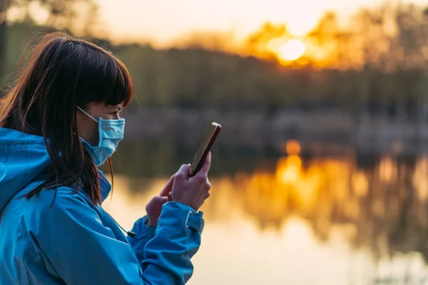 Virus Kvinna Skyddsmask Kollar Upp Mobiltelefon — Stockfoto