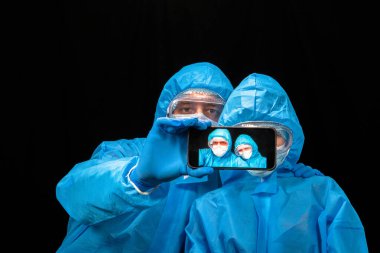 Virüs. Koruyucu antivirüs giysisi giyen kadın ve erkek selfie çeker..