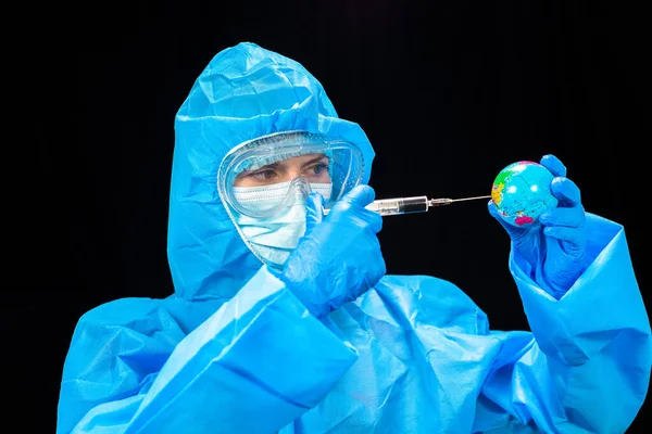 ウイルスだ 保護ウイルス対策のスーツの女性がミニチュア惑星地球への注射を注入する — ストック写真