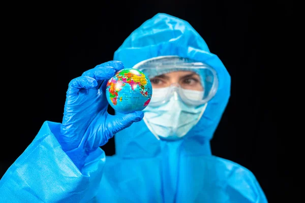 ウイルスだ 保護ウイルス対策のスーツの女性は彼女の手の中にミニチュア地球の場所を保持しています — ストック写真
