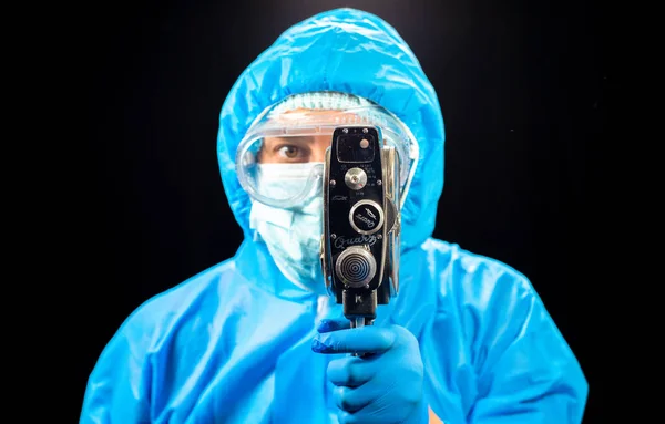 レトロな映画カメラ 保護ウイルス対策のスーツの男は彼の手にレトロな映画カメラを保持しています — ストック写真
