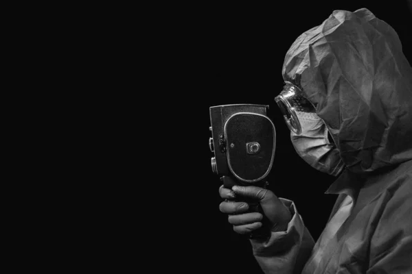 レトロな映画カメラ 保護ウイルス対策のスーツの男は彼の手にレトロな映画カメラを保持しています — ストック写真
