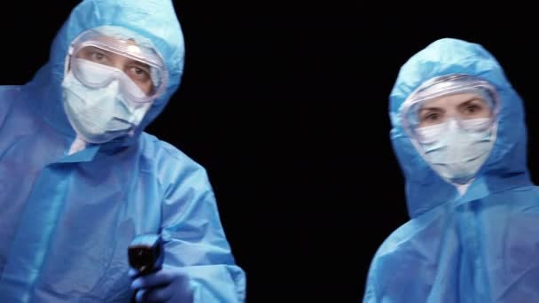 体温計だ ウイルス対策スーツのウイルス学者は非接触温度計で温度を測定します — ストック動画