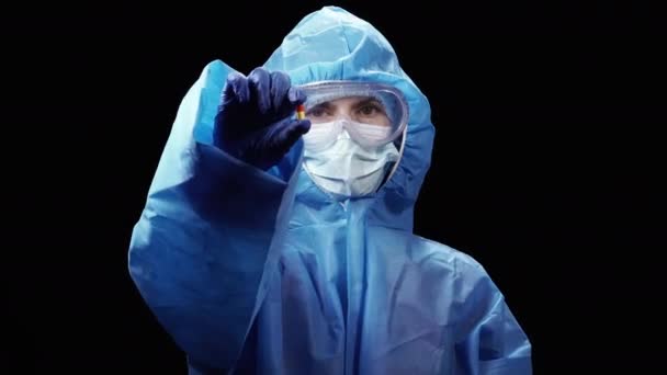 穿着防毒防护服的妇女手里拿着一颗病毒丸 — 图库视频影像