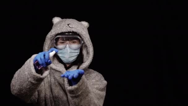 手消毒 一名戴着防护医疗面罩 身穿浴衣的妇女手里拿着手部清洁剂 — 图库视频影像