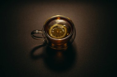 Siyah çay. Siyah arka planda bir dilim limonlu bir fincan siyah çay..