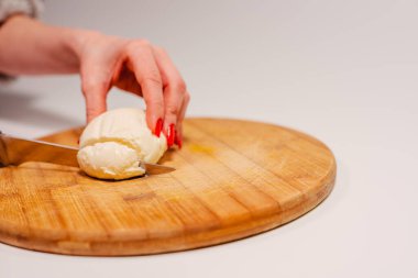 Mozzarella peyniri. Mutfak tahtasındaki kadın dilimlenmiş mozzarella peyniri.