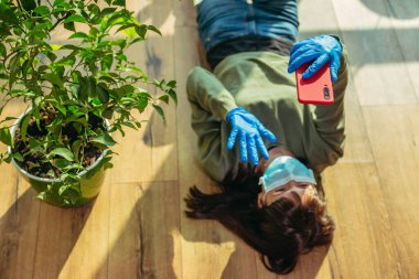 Karantinaya alın. Koruyucu tıbbi maskeli kadın internet üzerinden iletişim kuruyor..