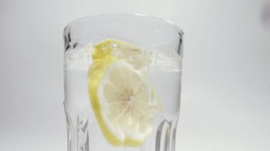 Limon. Bir limon bir bardak suya düşer. Ağır çekimde çekildi.