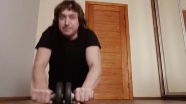 Evde şarj oluyor. Koruyucu maskeli bir adam virüs salgını sırasında evde egzersiz yapıyor..