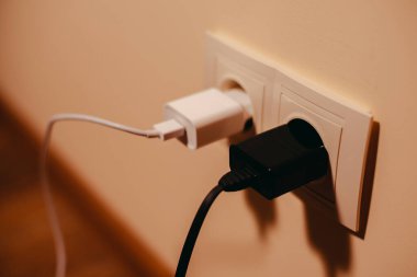 Şarj aleti. Cep telefonunun şarj aleti siyah ve beyaz..