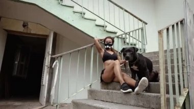 Kıyametten sonra. Hipoksik maskeli atletik kız tasmalı bir köpeği tutuyor..