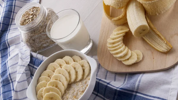 Harina de avena con plátanos y un vaso de leche —  Fotos de Stock