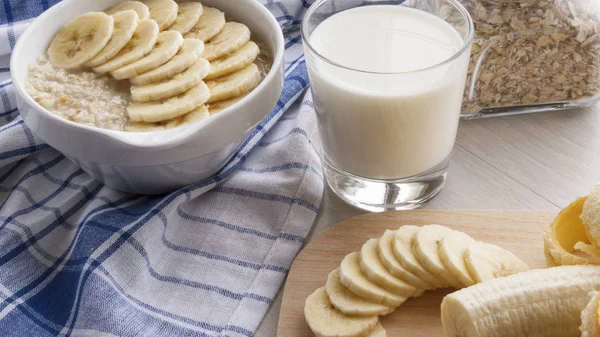 Harina de avena con plátanos y un vaso de leche —  Fotos de Stock