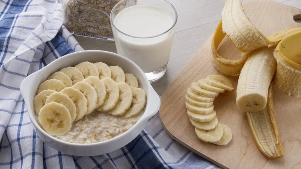 Harina de avena con plátanos y un vaso de leche —  Fotos de Stock