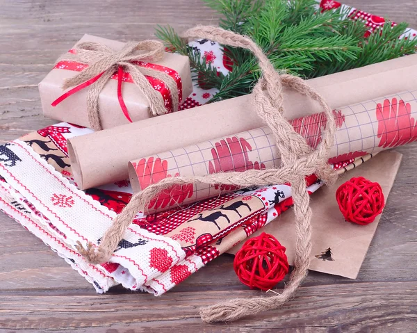 Kraft papír na balení dárků a dárkových rozhzhdestvensky na dřevěné pozadí. Vánoční pozadí s místem pro text. — Stock fotografie